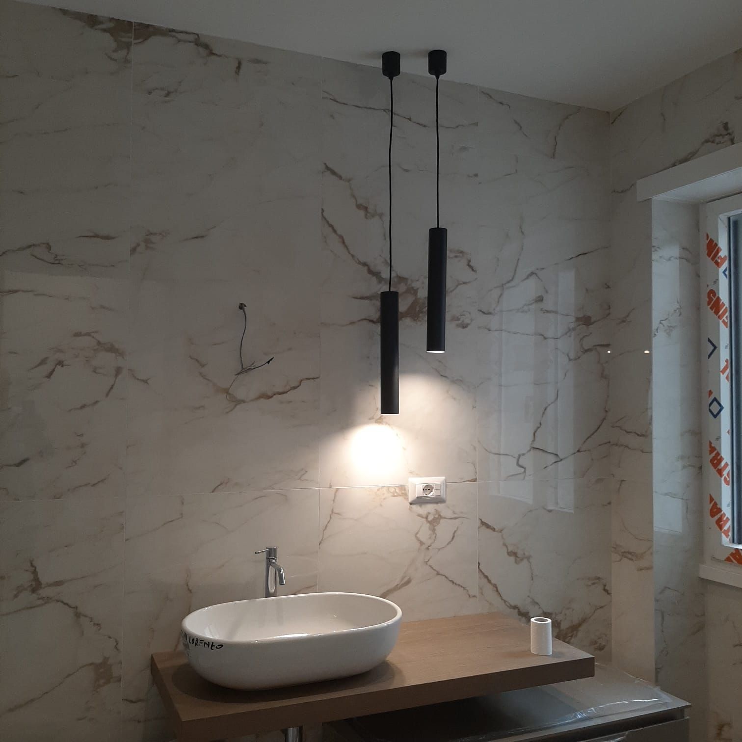 un bagno con pareti in marmo e un lavandino