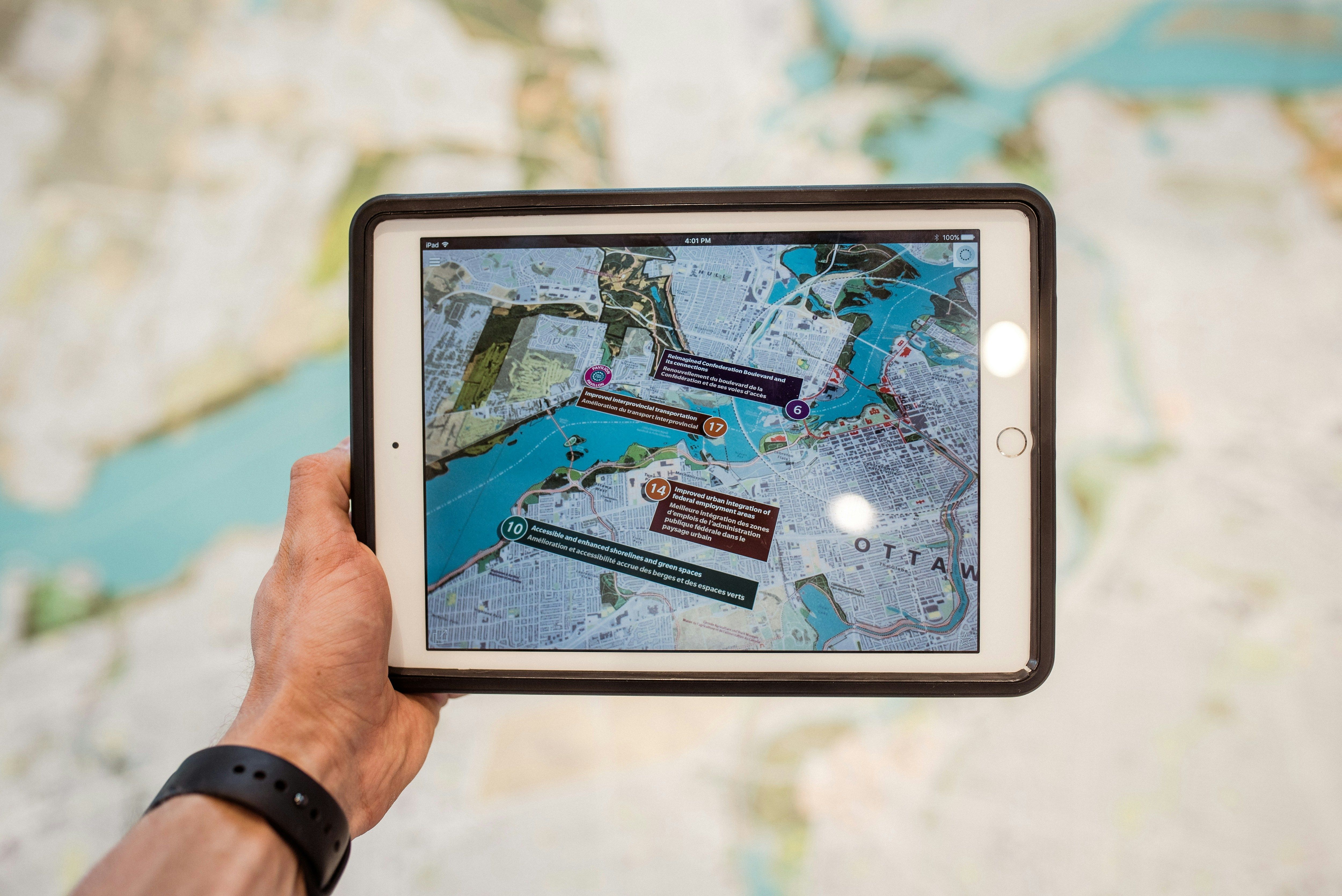 a person holding a tablet with a map on it